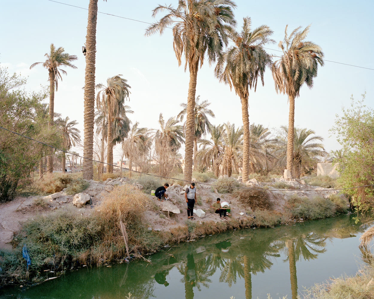 Men are fishing on a small tributary of the Shatt al-Arab in Basra. The city is located between Kuwait and Iran in southern Iraq. Basra nickname is the Venice of the East. The once-vibrant waters of Basra are now undrinkable and fetid. Iraq